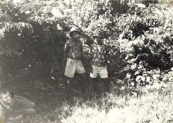 Twee papoea's met onze helmen bij het verdedigingskanon